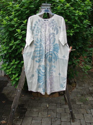 Barclay Long Tee Tie Back Dress Botanical Garden Rain Cream OSFA displayed on a wooden rack, showcasing its seamless design, rounded neckline, and drawcord back, epitomizing Bluefishfinder.com's vintage-inspired summer collection.