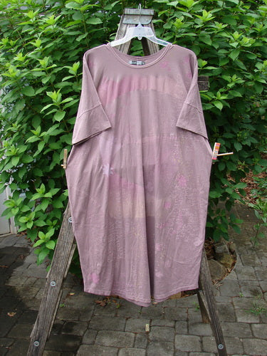 Barclay Long Tee Tie Back Dress Star & Moon Mottled Dark Mauve OSFA, featuring a seamless bodice, drawcord back, and star and moon design, is displayed draped over a wooden ladder outdoors.