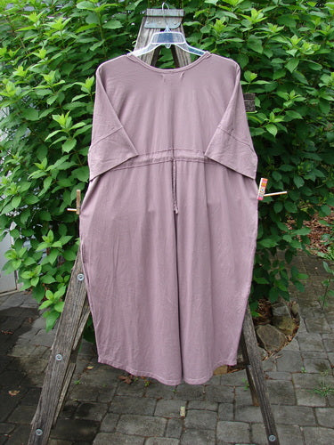 Barclay Long Tee Tie Back Dress in Mottled Dark Mauve, displayed on a wooden rack, showcasing its seamless front and star & moon theme paint, emphasizing its elegant, elongated silhouette.
