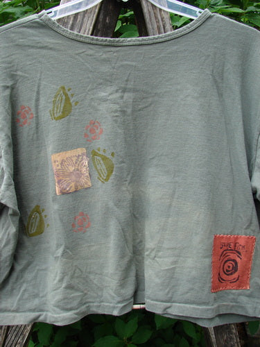 1991 Short Sleeved Crop Tee Fish Flower Olive Drab OSFA features a rolled neckline and vintage double fish and continuous flower design, highlighting its mid-weight cotton texture and slight fade at the rear center.