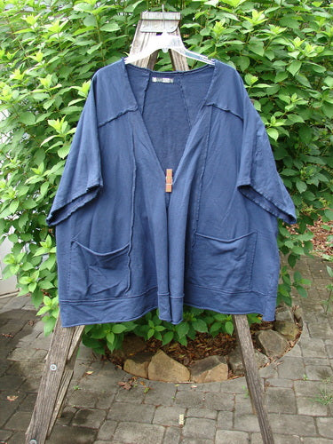 Barclay Photogram Open Front Jacket Rear Daisy Deep Navy OSFA displayed on a wooden rack, showcasing its wide three-quarter sleeves, angular hem, and distinctive raw edges, embodying Bluefishfinder.com's unique vintage style.