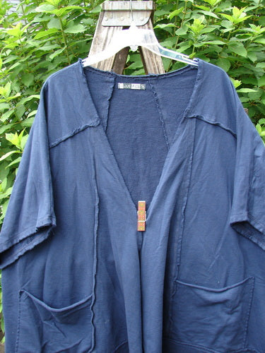 Barclay Photogram Open Front Jacket Rear Daisy Deep Navy OSFA, displayed on a hanger, features wide three-quarter sleeves, an open front, angular hem, and dolman shoulders, embodying Bluefishfinder.com's vintage, expressive style.