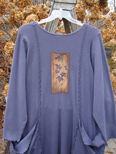 Barclay Patched Thermal Drop Pocket Dress features a long-sleeved, floral-patterned design with oversized wrap-around pockets and hand-painted patches, showcasing its unique A-line shape and exterior curly seams.