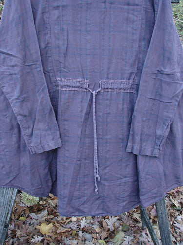 Barclay Draw Back Sectional Pullover Tunic, Forest Garden Wine Stripe, Size 2, displayed on a wooden pole, highlights its lightweight, short-sleeved design, embodying vintage Blue Fish Clothing's creative and expressive style.