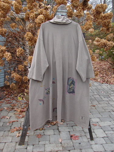 1994 Reprocessed Carriage Coat Ric Rack Raku OSFA displayed on a wooden rack, featuring an oversized silhouette, billowy collar, vintage buttons, and deep side pockets.