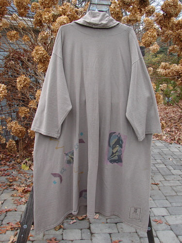 1994 Reprocessed Carriage Coat Ric Rack Raku OSFA displayed on a clothes rack, featuring an oversized collar, Blue Fish buttons, deep pockets, and a unique hemline.