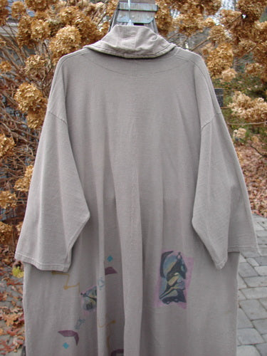 1994 Reprocessed Carriage Coat Ric Rack Raku OSFA with a hood, oversized buttons, deep side pockets, and a billowy collar. The coat has a flowing hemline and drop shoulders.