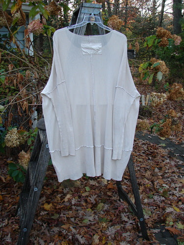 Barclay Cotton Mesh Exterior Stitch Sectional Overtop Unpainted Pink Cloud Size 2 displayed outdoors, showcasing its wide neckline, long sleeves, exterior stitchery, and drop hem panel, embodying Bluefishfinder.com's vintage, creative style.