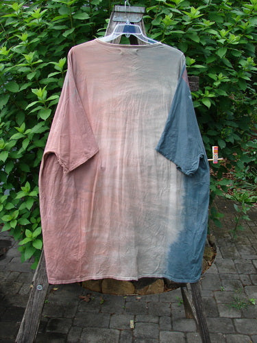 Barclay Art Tee Bicycle Floral Basket Mottled Mauve Gray OSFA displayed on a swing, showcasing its tunic length, loose three-quarter sleeves, and upward rounded front hem with floral basket design.