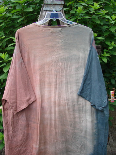 Barclay Art Tee Bicycle Floral Basket Mottled Mauve Gray OSFA displayed on a swing, showcasing its loose three-quarter sleeves, rounded neckline, and varying hemline against an outdoor backdrop.