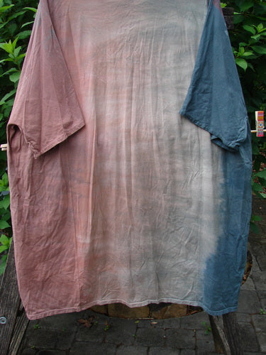 Barclay Art Tee Bicycle Floral Basket Mottled Mauve Gray OSFA displayed outdoors, showcasing its longer tunic length, drop shoulders, loose three-quarter sleeves, and unique hemline against a natural setting.