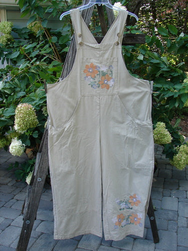 2000 Parachute Overall Pant Jumper Floral Dove Size 2 displayed on a wooden ladder, featuring a floral design, oversized painted front bib pocket, deep side pockets, and adjustable shoulder straps with vintage hardware.