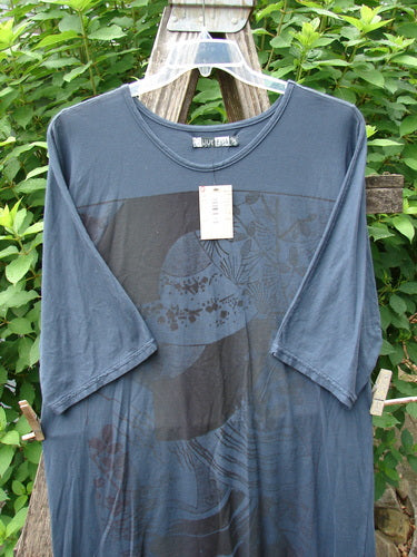 Barclay NWT Tournesol Slim Tunic Turn Moon Navy OSFA displayed on a wooden fence, showcasing its drop shoulders, loose three-quarter sleeves, and mid-length design with a rounded neckline and varying hemline.