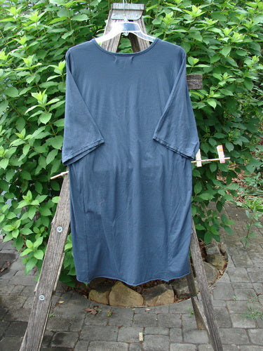 Barclay NWT Tournesol Slim Tunic Turn Moon Navy OSFA displayed on a wooden ladder, featuring a mid-length design with drop shoulders, loose three-quarter sleeves, and a rounded neckline, highlighting its unique hemline.