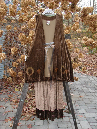 1997 Velvet Sanskrit Cosmos Duo Mandorla OSFA Size 2: A brown velvet vest and white dress on a wooden stand. Elegant and flowing winter holiday collection from Blue Fish Clothing.