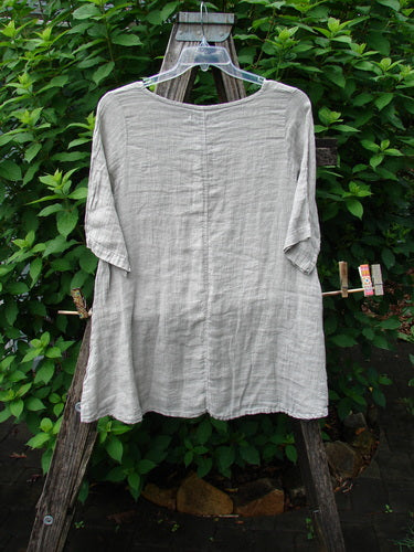 Barclay NWT Linen Springtime Top Unpainted Cloud Size 0 displayed outdoors, highlighting its flowy A-line shape, rounded neckline, and almost three-quarter sleeves. Perfect for expressing individuality with comfort.