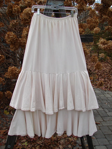 1993 Two Story Skirt Unpainted Tea Dye Small Size 2 on a clothes rack, featuring ruffles and a full, flouncy design with a wide lower sweep.