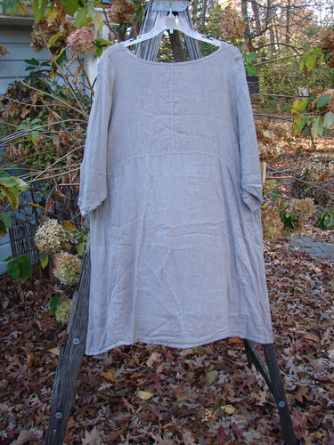 Barclay Linen Urchin Pocket Dress Unpainted Sand Size 2 displayed on a wooden stand, showcasing its lightweight short sleeves and elegant drape, aligned with Bluefishfinder.com's vintage-inspired clothing ethos.