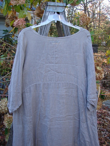 Barclay Linen Urchin Pocket Dress in Unpainted Sand, Size 2, displayed on a hanger outdoors. The dress is lightweight with short sleeves, embodying Bluefishfinder.com's vintage clothing ethos.