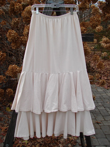 1993 Two Story Skirt Unpainted Tea Dye Small Size 2, featuring double-layered cotton jersey with a full elastic waistline and flouncy tiers, displayed on a clothes rack.