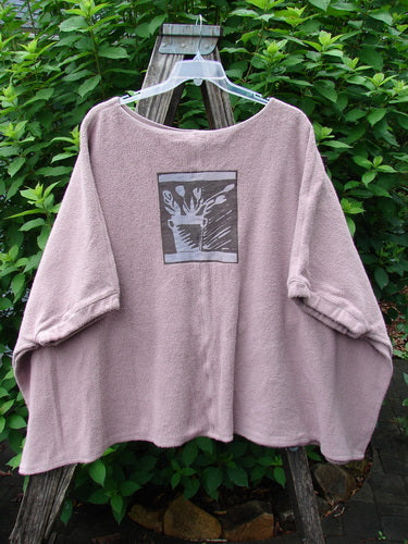 Barclay Celtic Moss Patched Poncho Single Flowerpot Mallow OSFA displayed on a wooden swing, highlighting its open sides, gathered sleeves, and cozy Sherpa fabric texture, embodying Bluefishfinder.com's vintage, expressive style.