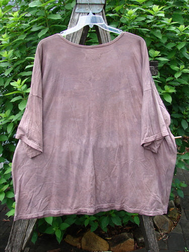 Barclay Center Seam Wide Line Tee Fern Fare Mottled Mauve OSFA displayed on a clothes rack, showcasing its rounded ribbed neckline, drop shoulders, and boxy shape with a distinctive vertical center seam.