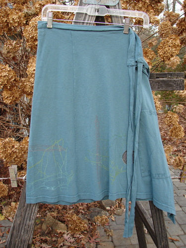 2000 NWT Grid Patch Wrap Skirt in Puddle. Organic cotton skirt with long belt, sectional panels, and stitched painted patch. Versatile length and stylish design.