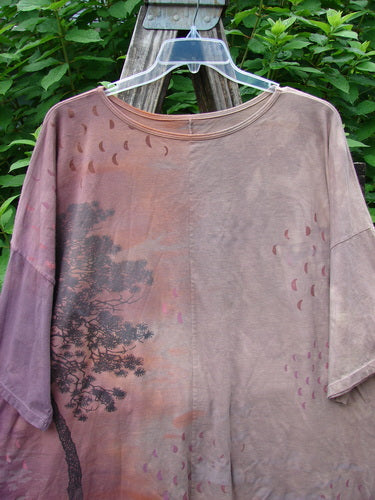 Barclay Center Seam Wide Line Tee Tree Moons Mottled Sunset OSFA displayed on a swinger, showcasing its wide, boxy shape, drop shoulders, and distinctive vertical center seam in an outdoor setting.