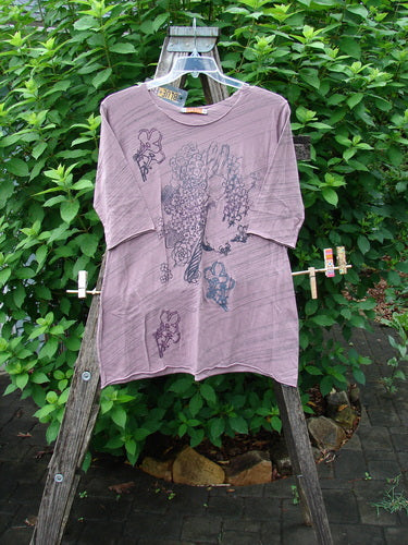 Barclay NWT Viscose Horizon Raw Cut Tee in Tulsi Rose Striation displayed on a swinger, featuring a floral cluster and feather design with raw cut neckline and three-quarter sleeves.