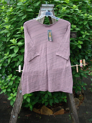 Barclay NWT Viscose Horizon Raw Cut Tee features a raw cut neckline, three-quarter sleeves, and floral cluster pattern, displayed on a clothes rack, emphasizing its unique Tulsi Rose Striation design.