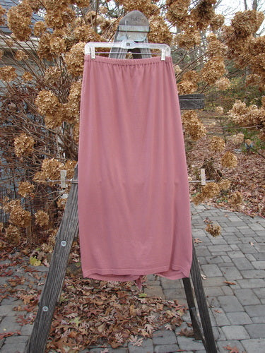 1994 Gather Skirt Unpainted Gourd Size 1: A pink skirt on a wooden ladder, with a pink fabric on a pole.