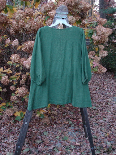 Barclay Linen Deep V Single Button Cardigan in Jade, displayed on a hanger. Features a deep V neckline, single button closure, empire waist, billowy three-quarter sleeves, and A-line shape.
