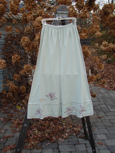 1998 Botanicals Sparrow Skirt Garden Bug Grasshopper Size 1 displayed on a rack, showcasing dragonfly embroidery, full elastic waistline, vertical stitchery, lower horizontal panels, and a wide A-line flare.