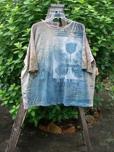 Barclay NWT Center Seam Wide Line Tee features a boxy shape, drop shoulders, and ribbed neckline. Displayed outdoors, this tee showcases the Tulip Garden theme with a central seam design.