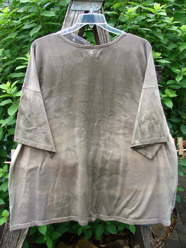 Barclay NWT Center Seam Wide Line Tee Tulip Mottled Brown Blue OSFA displayed on a rack, showcasing its boxy shape, rounded neckline, and distinctive vertical center seam with tulip garden design.