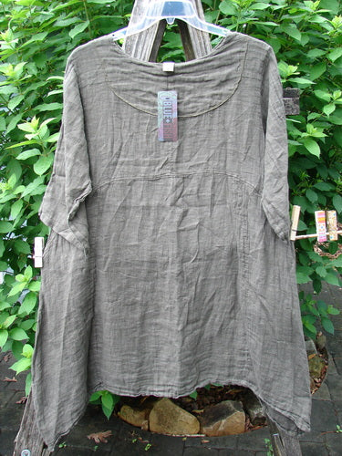 Barclay NWT Linen Cross Over Urchin Pocket Dress Unpainted Earth Size 1, featuring a smart V-neck, drop shoulders, and double side pockets, displayed hanging outdoors, showcasing its unique design and craftsmanship.