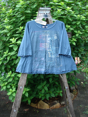Barclay NWT Crop A Lined Cafe Tee Play Dress Up Echo Blue Size 0 displayed on a wooden stand, showcasing its unique A-line shape, rounded neckline, and curly edgings, reflecting vintage Blue Fish Clothing style.