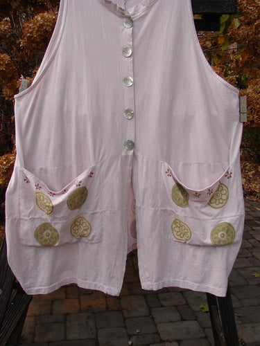 Barclay Shell Button Drop Pocket Vest in Pinwheel Pink Tile Size 2, featuring front shell buttons and two drop pockets, deep V neckline with a stand-up border, and an A-line shape with reverse bell sides.