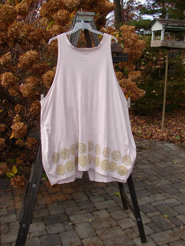 Barclay Shell Button Drop Pocket Vest in Pink Tile with gold designs, displayed on a rack, featuring two front pockets, shell buttons, and a deep V neckline.