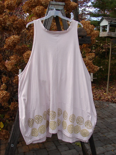 Barclay Shell Button Drop Pocket Vest Pinwheel Pink Tile Size 2 displayed on a clothesline, showcasing its intricate gold designs, deep V neckline with a border, and distinctive painted pockets.