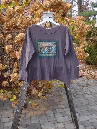 Barclay PMU Patched Batiste Long Sleeved A Line Tee Love Dove Brum Size 2 displayed on an outdoor swinger, featuring longer narrow sleeves, rounded neckline, and raw rolled edgings.