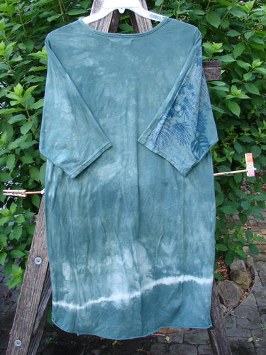 Barclay Tournesol Slim Tunic Beach Palm Mottled Green Earth OSFA displayed on a hanger, showcasing its loose three-quarter sleeves, rounded neckline, and varying hemline, emblematic of Bluefishfinder's vintage-inspired style.