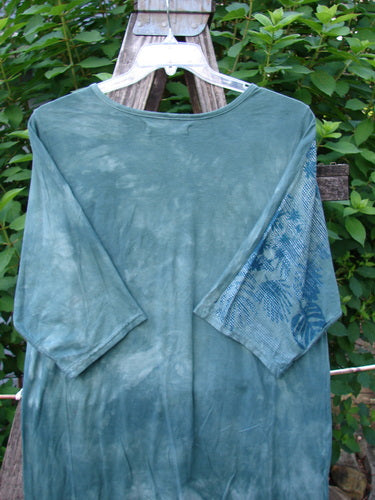 Barclay Tournesol Slim Tunic Beach Palm Mottled Green Earth OSFA displayed on a hanger, showcasing its drop shoulders, three-quarter sleeves, round neckline, and varying hemline, reflecting Bluefishfinder.com's vintage style.