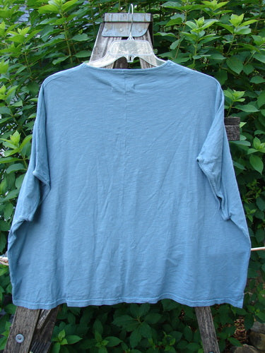 Barclay Cotton Slub Cricket Cap Sleeve Tee Camo Cat Light Teal OSFA displayed on a hanger, showcasing its seamless cap sleeves, boxy shape, and unique camo cat design. Ideal for a casual and creative style.