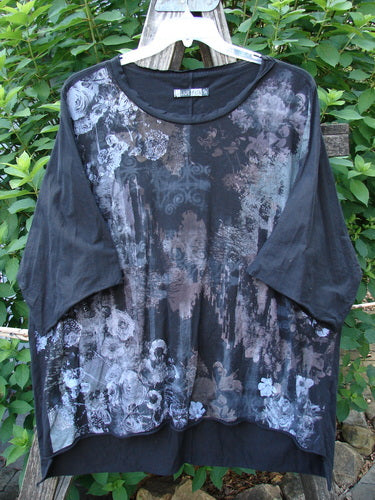 Barclay Raw Edge Flutter Collar High Low Top Dogwood Shadow Black OSFA features a rounded batiste flutter neckline and raw edge dolman sleeves, showcasing a wide boxy shape with a hi-low hemline.