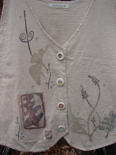 1995 Folk Vest in Flaxen, Size 2: Close-up of a shirt with ceramic buttons, tuxedo-style front hemline, and sun star theme paint.