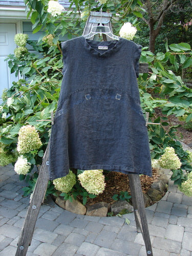 Barclay Linen Mid Layer Cap Sleeve Tunic Heart Black Size 0 displayed on a wooden stand, showcasing its curved hemline, empire waist seam, mock mandarin collar, and tiny heart theme.