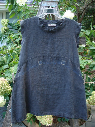 Barclay Linen Mid Layer Cap Sleeve Tunic Heart Black Size 0 hanging on a clothesline, showcasing a downward curved front and rear drop empire waist seam, with a mock mandarin collar.