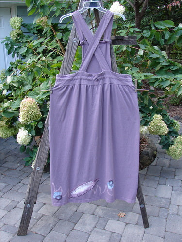 1996 Souvenir Jumper Turn Path Petunia Size OSFA displayed on a wooden ladder, showcasing its unique features like a gathered skirt, criss-cross back, and painted bib.