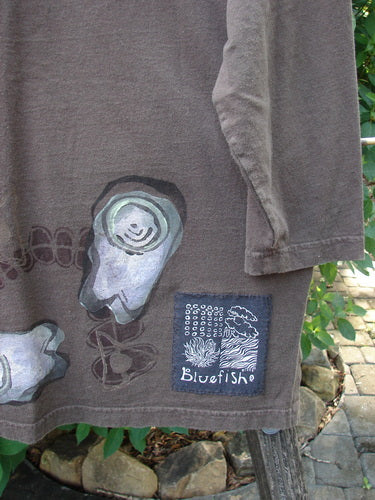 Close-up of the 1998 Long Sleeved Vented Tee Tumble Stone Stick Size 1, showcasing the thicker rib neckline, varying shirttail hemline, and specialized signature Blue Fish patch.